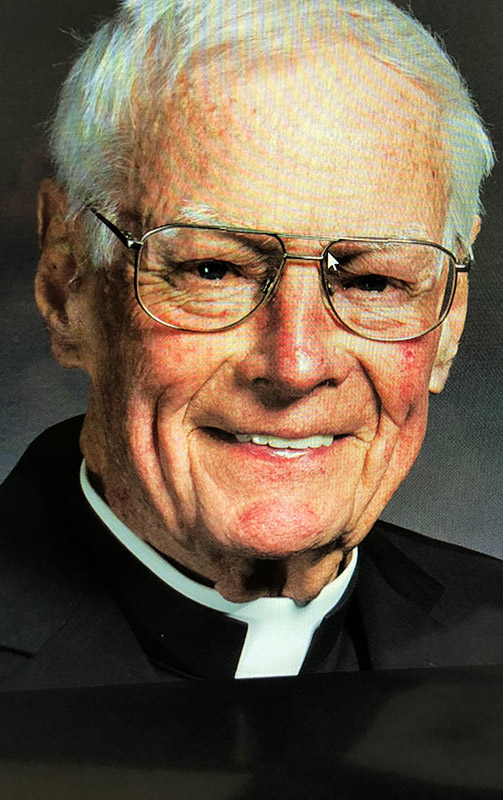 older white man in glasses and clerical collar
