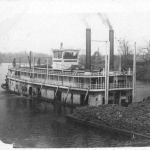 Steamboat pushing barge on river
