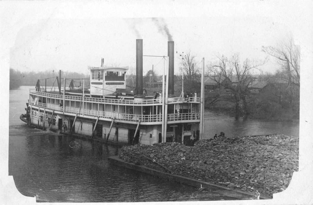 Steamboat pushing barge on river