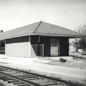 Single story building beside railroad tracks