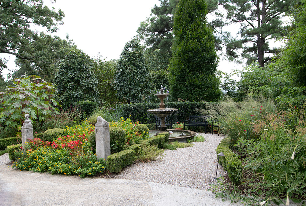 Garden with birdbath and variety of plants and flowers and walkway