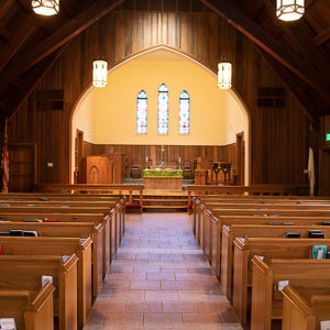 Church interior with wooden pulpit and pews and stone aisle