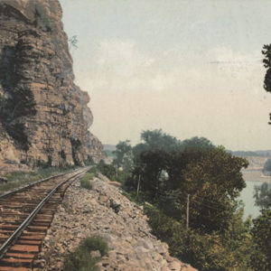 Railroad track between bluff and river