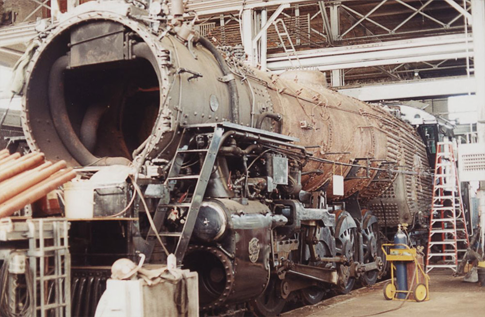 Partially disassembled locomotive in large interior space