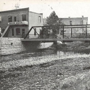 Buildings and bridge crossing creek