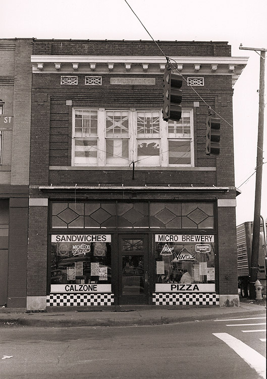 Multistory brick building with signs saying "Sandwiches