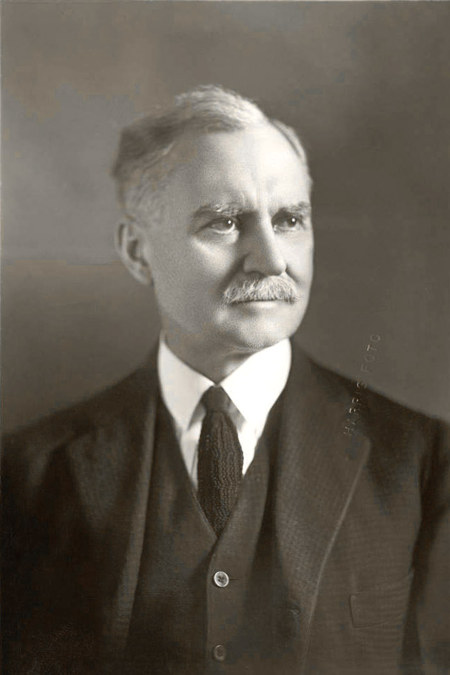 Mustachioed white man in suit