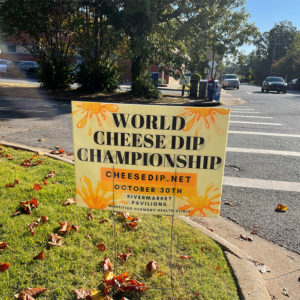 Yard sign next to street saying "World Cheese Dip Championship"