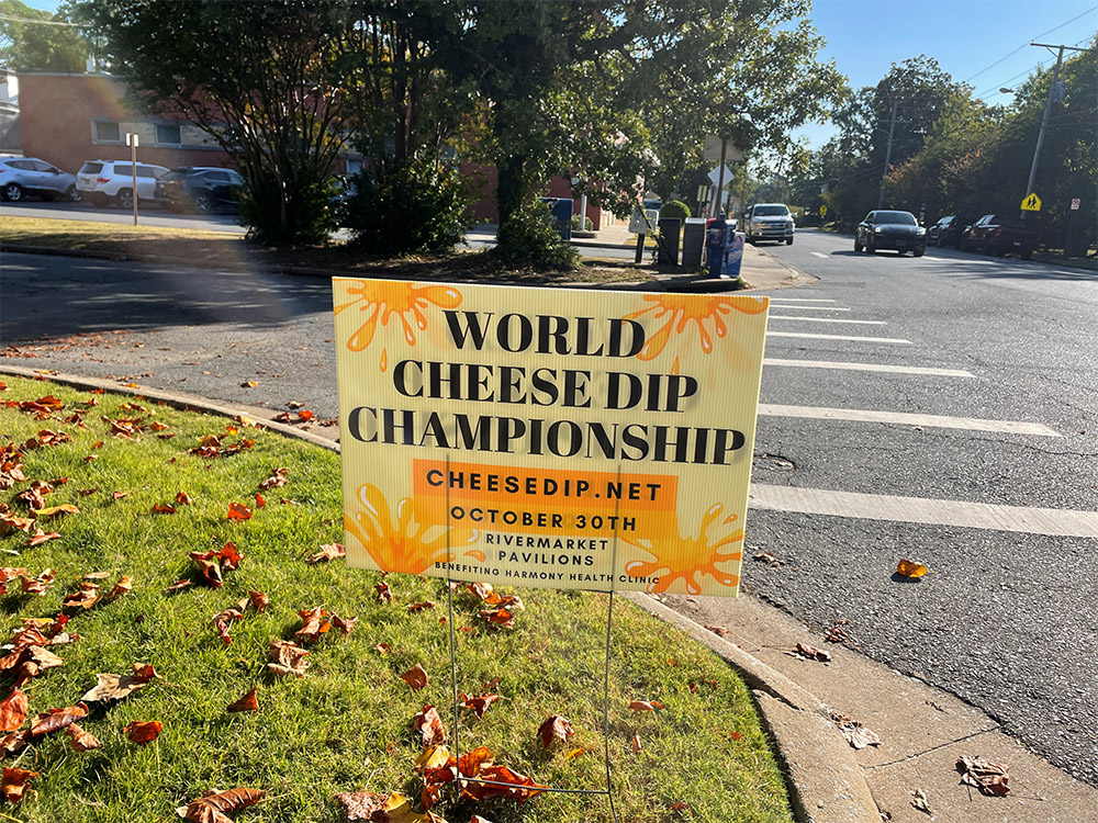 Yard sign next to street saying "World Cheese Dip Championship"