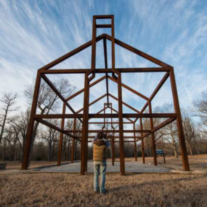 Person standing before large building frame