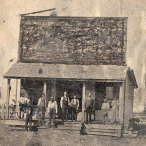 People standing on porch of storefront