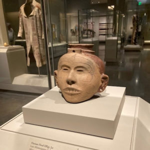 Head shaped pot on display in glass case