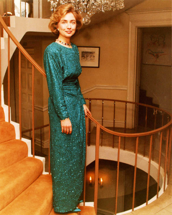 White woman on stairs in blue-green formal gown