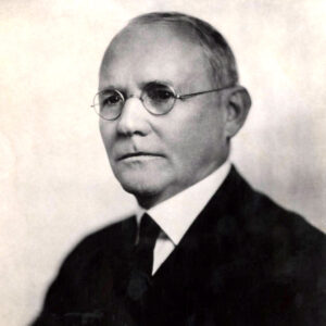 White man in suit and glasses