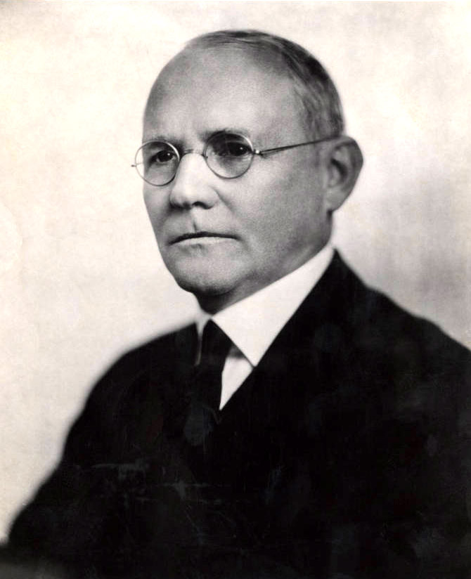 White man in suit and glasses