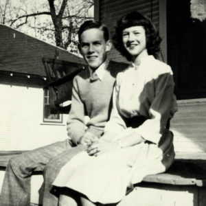 Young man and young woman sitting together on a porch