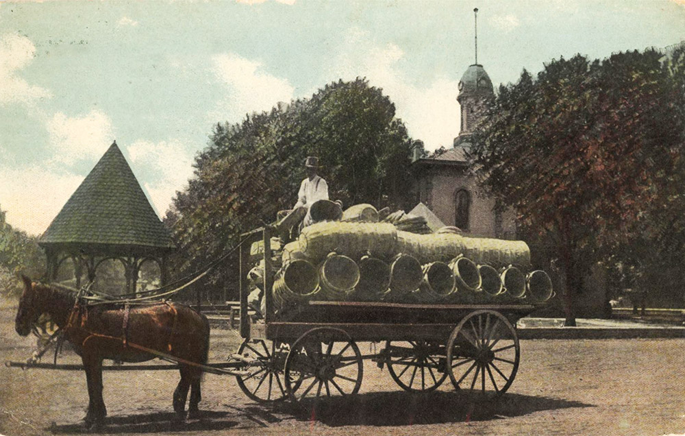 Man in horse-drawn wagon filled with baskets