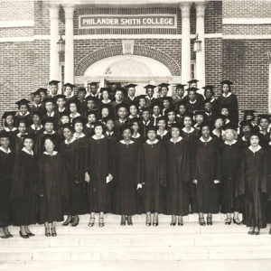 Large group of African Americans in cap and gown on steps of building with "Philander Smith College" on the front