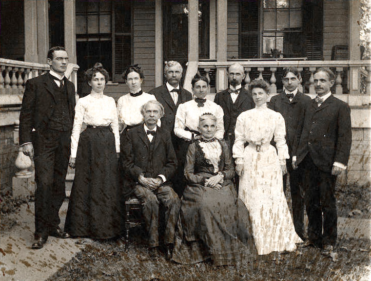 Large group of formally dressed white men and women posing for photo