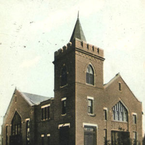 Multistory brown brick building with large spire