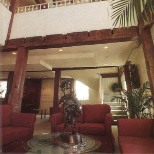 Lobby at the interior of a multistory building with ferns and red couches