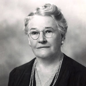 portrait of white woman wearing glasses and a string of pearls