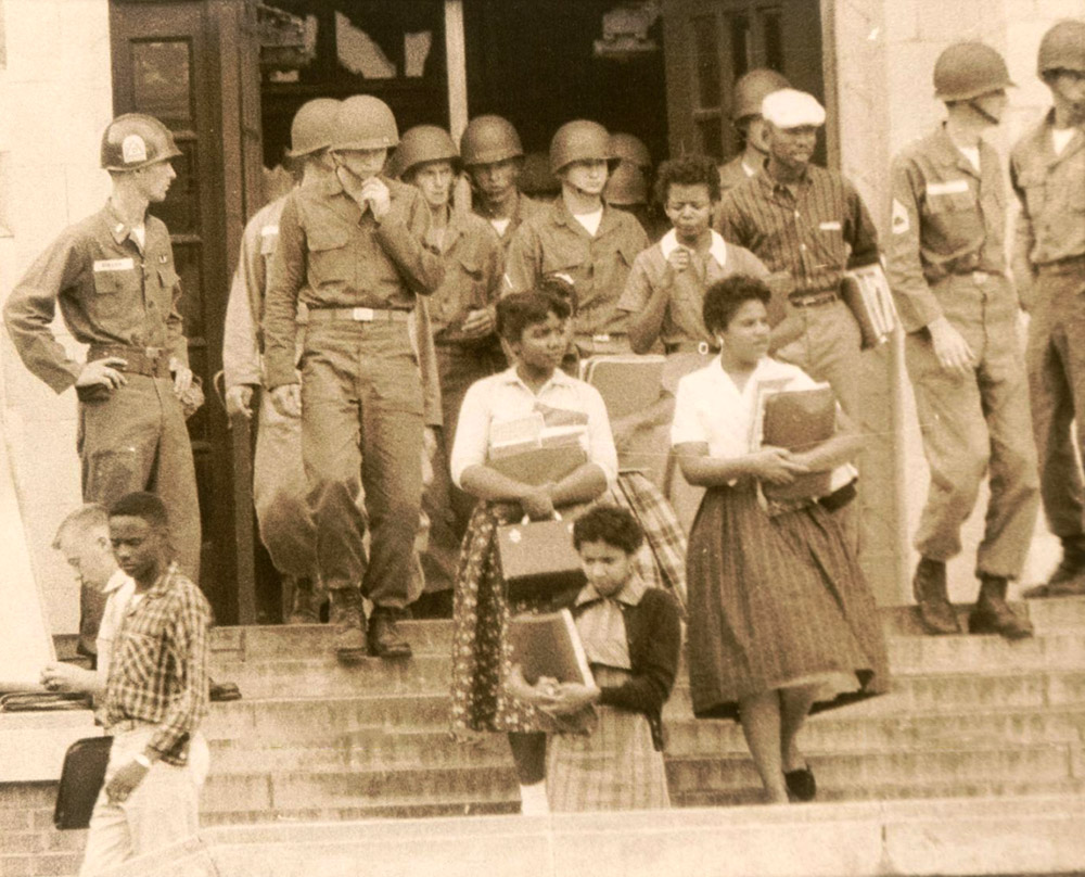 African American children on steps in front of white soldiers in uniform