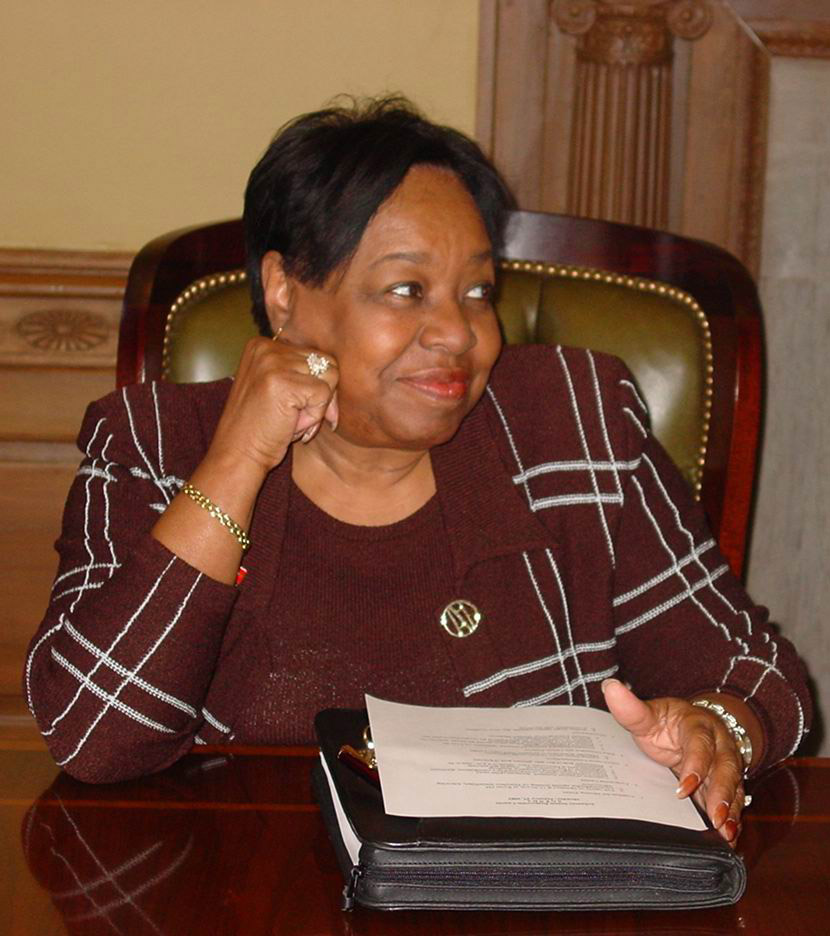African American woman sitting at desk holding book