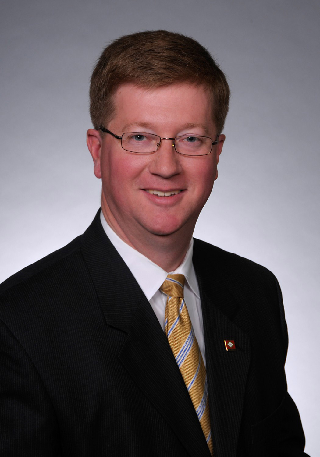 White man with glasses wearing suit and tie