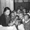 African American woman dispensing medicine to African American children