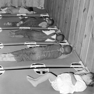 African American children sleeping on cots