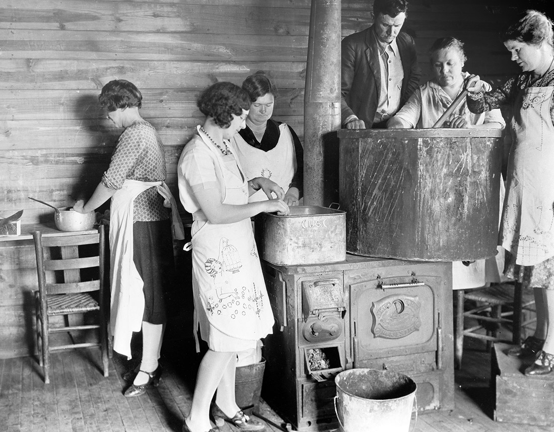 Five women and one man at work cooking