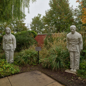 Statues of Asian man and woman in garden area