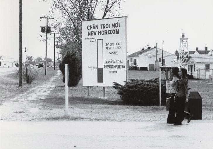 Women walking past Fort Chaffee sign