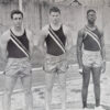 Three white young men and one African American young man in track uniforms