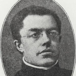 White man in glasses and priest's garb