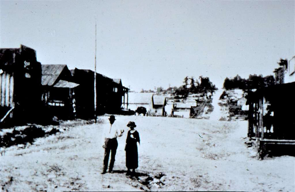 man and white woman standing in street in small town