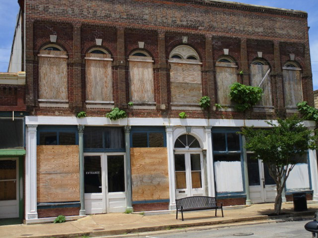 Partially boarded up two story brick building