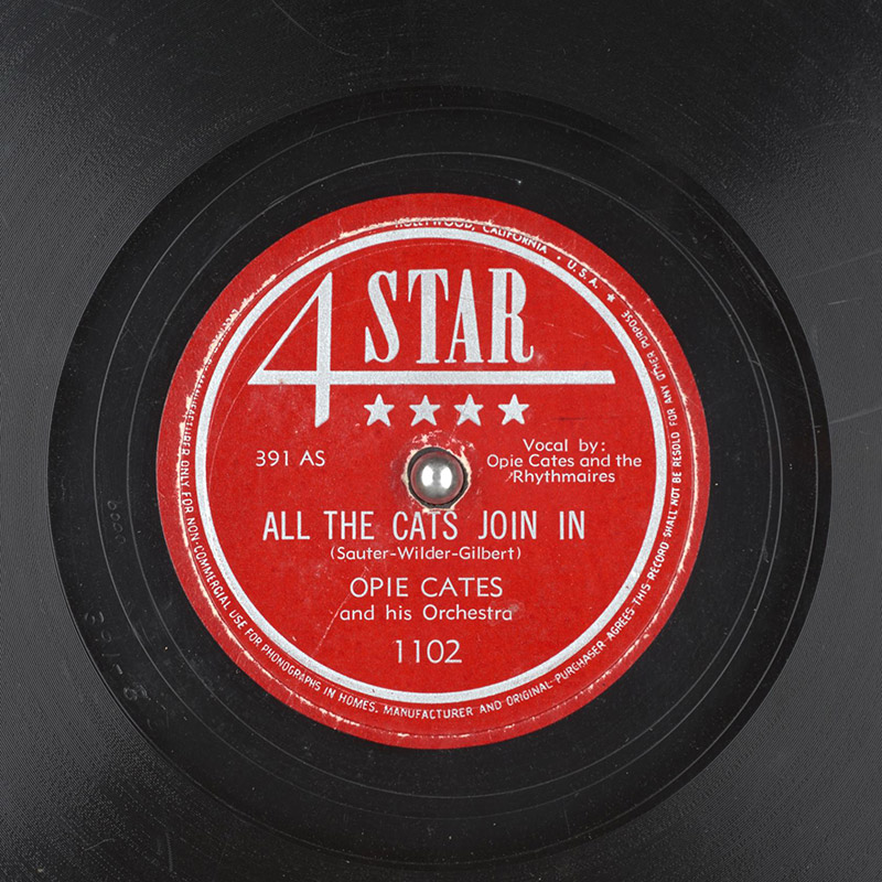Vinyl record with red label showing "All the Cats Join In"