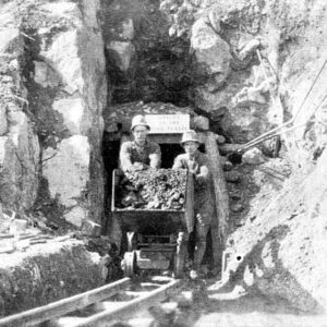 Two white men emerging from a tunnel with a cart