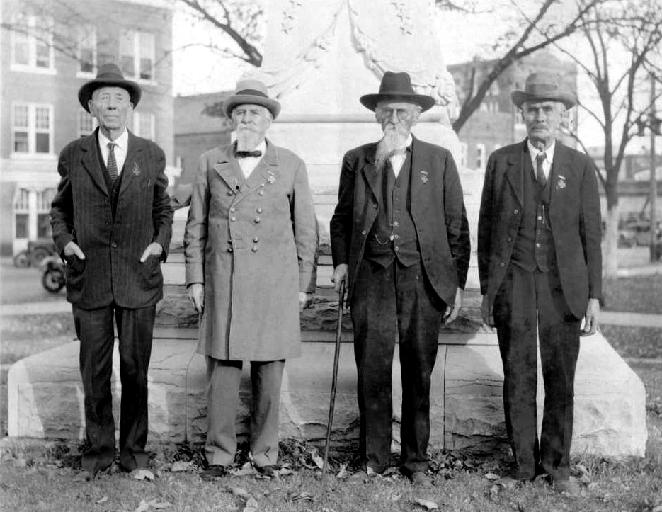 Four older white men standing in front of plynth