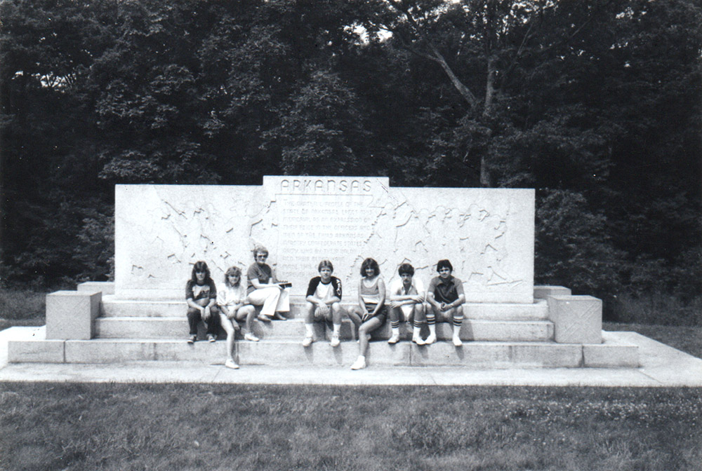 Group of white teens in front of stone monument