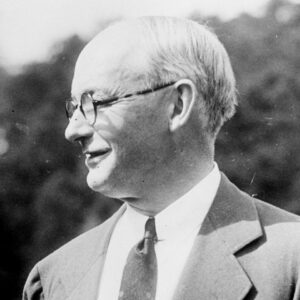 White man in suit and glasses shown in profile