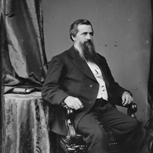 White man with beard sitting in chair