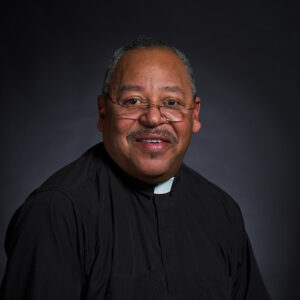 African American man in glasses and priest's frock