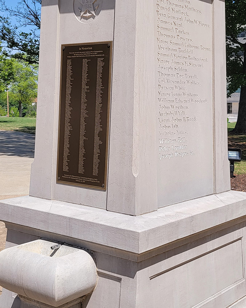 Concrete sculpture with metal plaque insert listing names under "In Memoriam"