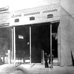 men standing before brick storefront building