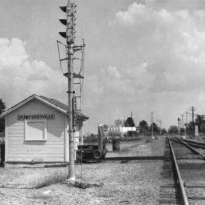 Small white wooden building next to railroad tracks