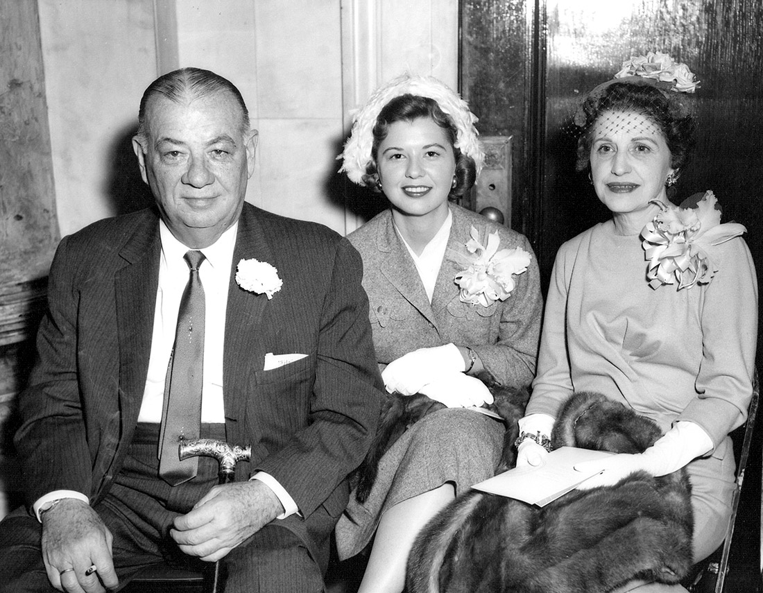 White man and two white women seated and dressed up