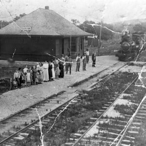 People waiting beside railroad tracks